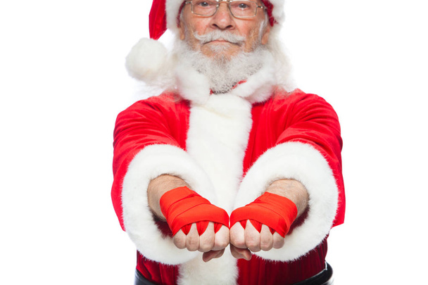 Різдво. Крупним планом два кулаками Санта-Клауса з червоним пов'язки рана на них для боксу. Кікбоксинг, бокс, карате. Ізольовані на білому тлі. - Фото, зображення