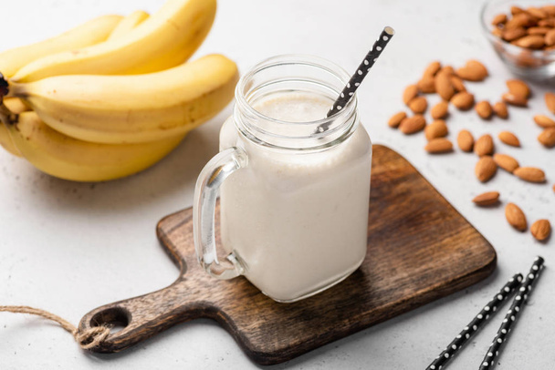 Banana protein smoothie in drinking glass - Photo, image
