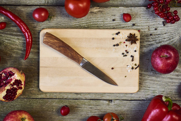Fresh vegetables and ingredients for cooking around cutting board on  wooden background, top view, place for text - Photo, Image