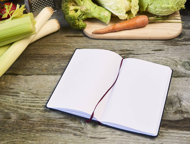 libro de recetas abierto con verduras sobre fondo de madera
. - Foto, imagen