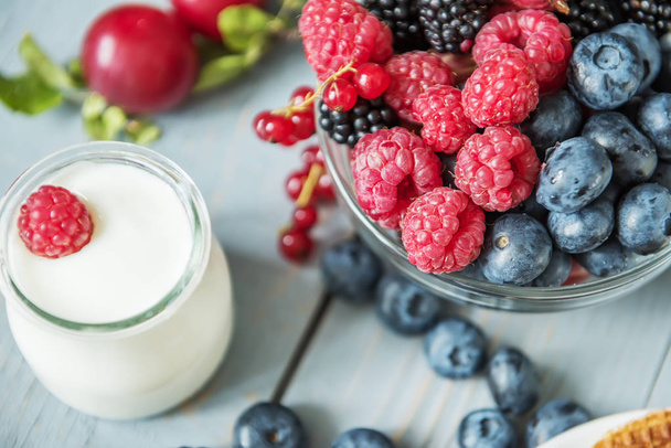 Yogurt and various berries on a light background. A useful delicious breakfast - Fotoğraf, Görsel