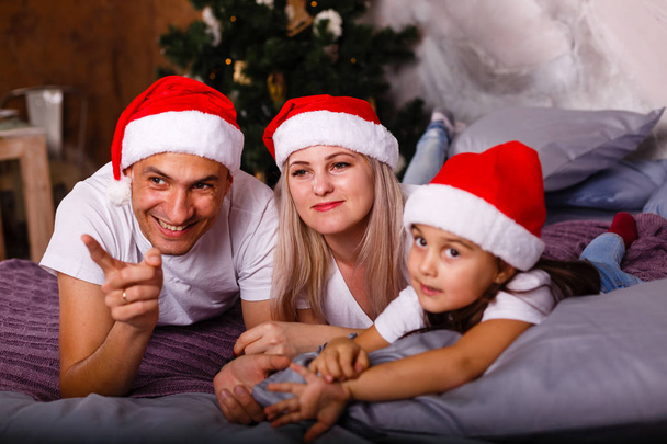Feliz familia joven celebrando la Navidad en los sombreros de Santa
 - Foto, imagen