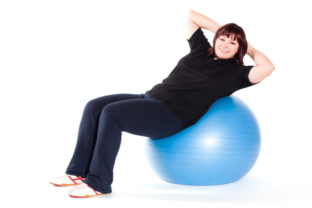 Tiro de una mujer joven con sobrepeso ejercicio en la pelota de fitness de nuevo
 - Foto, Imagen