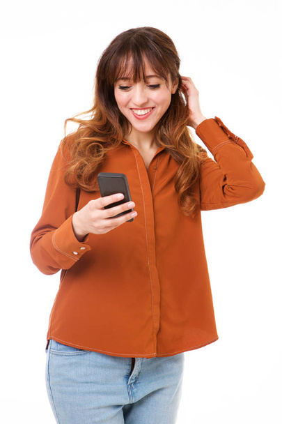 Retrato de una joven sonriente mirando el teléfono inteligente
 - Foto, Imagen