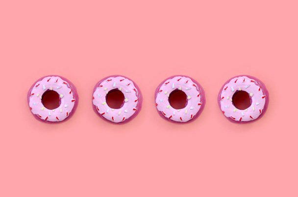 Muchos pequeños donuts de plástico se encuentra en un fondo de colores pastel. Piso establecer un patrón mínimo. Vista superior
 - Foto, imagen