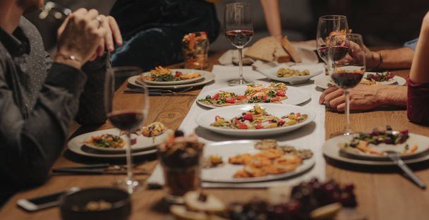 Ryhmä kaupunkilaisia, jotka syövät viiniä kotona illalliskutsuilla.
. - Valokuva, kuva