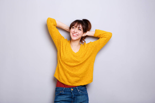 Portrait of happy young woman laughing with hands behind head - Foto, imagen