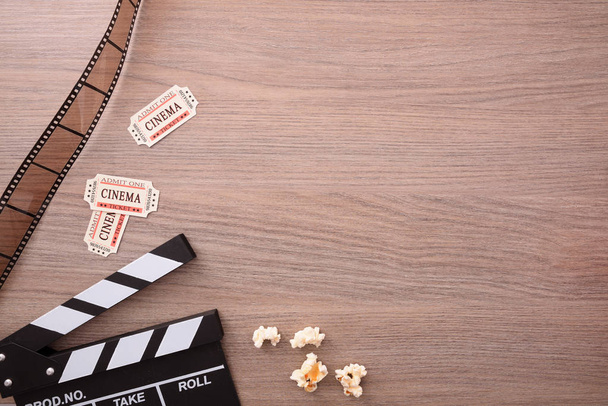 Equipment and elements of cinema on wooden table. Concept of watching movies. Vertical composition. Top view. - Photo, image