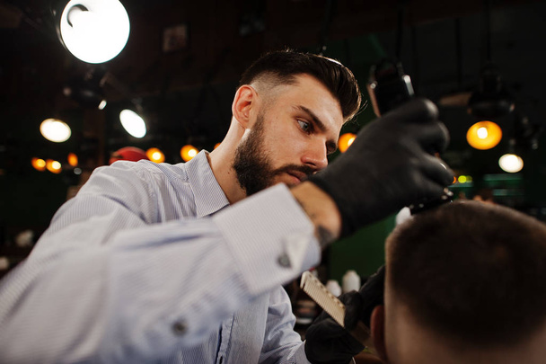 Handsome bearded man at the barbershop, barber at work. - 写真・画像