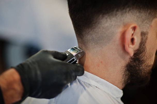 Handsome bearded man at the barbershop, barber at work. Close up nape. - Photo, image