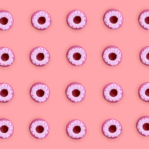 Muitos pequenos donuts de plástico estão em um fundo colorido pastel. Plano leigos padrão mínimo. Vista superior
 - Foto, Imagem