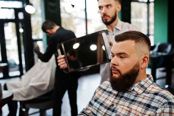 Handsome bearded man at the barbershop, barber at work. - Foto, imagen