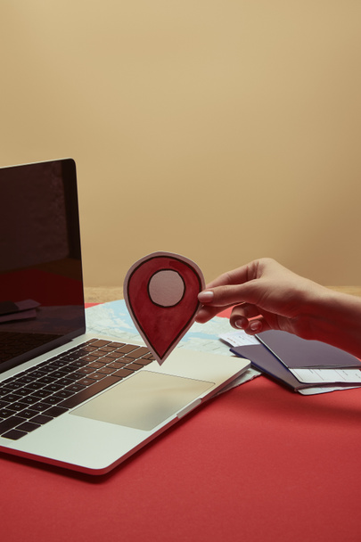 imagem cortada de mulher segurando sinal de localização perto do laptop
 - Foto, Imagem