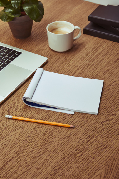 laptop, notebook and pencil on wooden brown tabletop - Fotografie, Obrázek