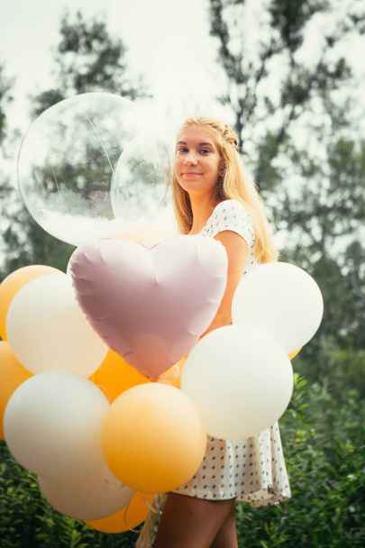junges Mädchen mit Luftballons auf Naturhintergrund. - Foto, Bild