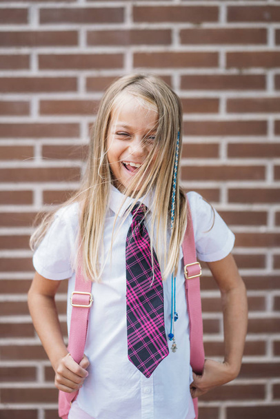 Счастливая милая школьница позирует на улице
 - Фото, изображение