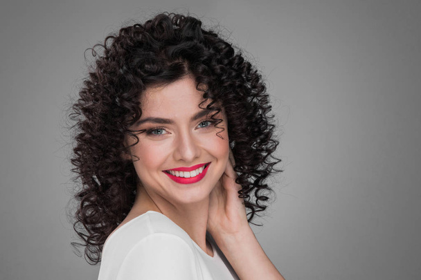 Studio portrait of smiling curly hair woman - Foto, afbeelding
