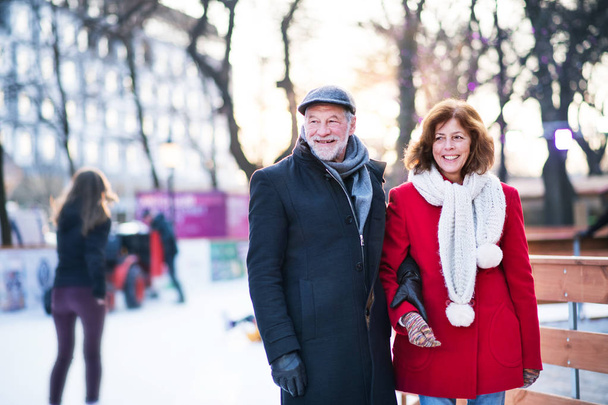 Senior couple on a walk in a city in winter. - 写真・画像
