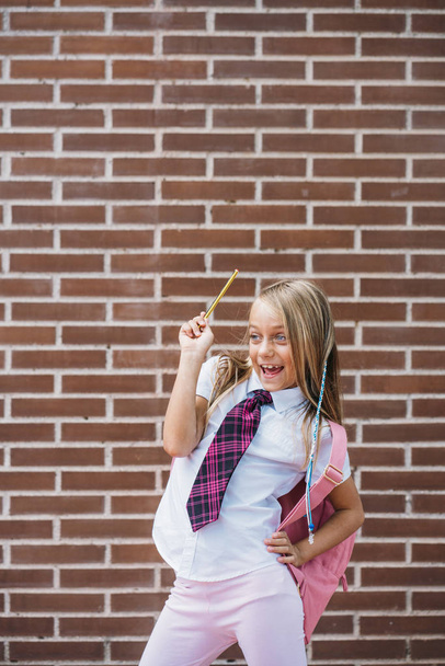 Щаслива мила школярка позує на вулиці
 - Фото, зображення
