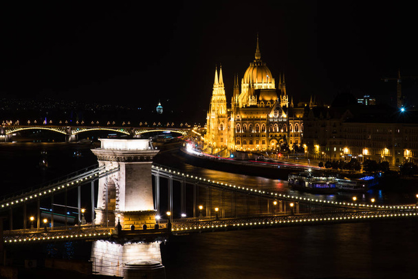 Budapestin eduskunta näkymä Tonavan ja sillan yli yöllä
 - Valokuva, kuva