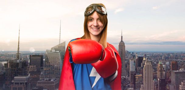Superheldenmädchen mit Boxhandschuhen in einer Wolkenkratzerstadt - Foto, Bild
