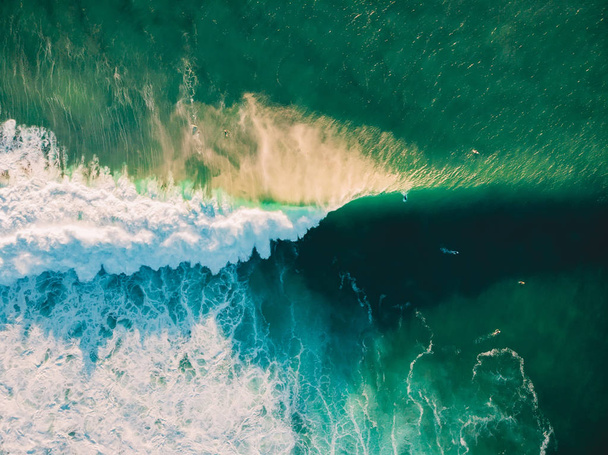 Vue aérienne d'une vague qui s'écrase dans l'océan avec une lumière du coucher du soleil chaude. La vague s'écrase sur le récif. Vue du dessus
 - Photo, image
