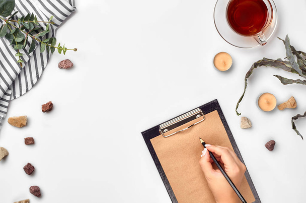 A woman hands writing on empty book note, diary, spread mockup, top view, studio. Cup of tea break. - Fotografie, Obrázek
