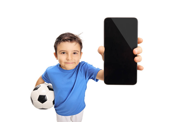 Little footballer showing a cell phone isolated on white background - Φωτογραφία, εικόνα