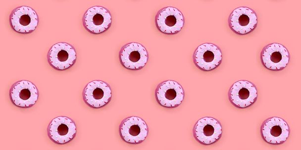Many small plastic donuts lies on a pastel colorful background. Flat lay minimal pattern. Top view - Photo, Image