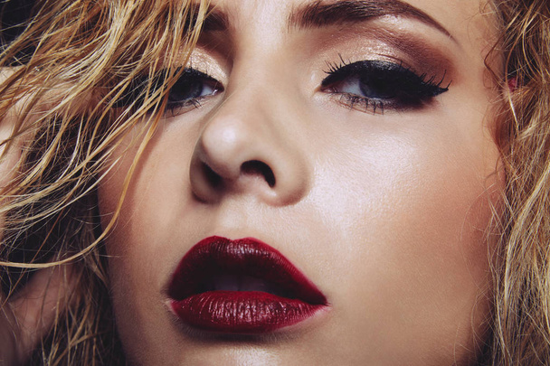 Gesicht einer hinreißenden jungen Frau mit roten Lippen und leuchtendem Augen-Make-up - Foto, Bild