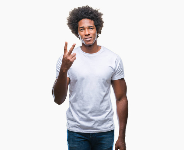 Αφρο αμερικανικό άνθρωπος πέρα από το απομονωμένο υπόβαθρο δείχνει και δείχνει προς τα επάνω με τα δάχτυλα αριθμός δύο ενώ χαμογελώντας αυτοπεποίθηση και χαρούμενοι. - Φωτογραφία, εικόνα