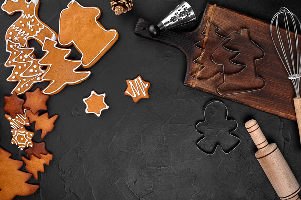 Christmas homemade gingerbread cookies, spices and cutting board on dark background with copy space for text top view. New year and christmas postcard - Fotografie, Obrázek