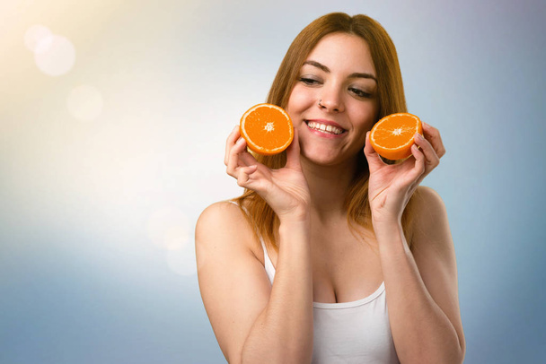 Красивая молодая девушка держит апельсиновый сок на несосредоточенном фоне
 - Фото, изображение