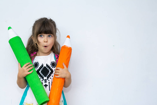 Портрет шокованої молодої дівчини в повсякденному одязі, що вказує великий олівець на копіювальному просторі, ізольованому на білому тлі
 - Фото, зображення