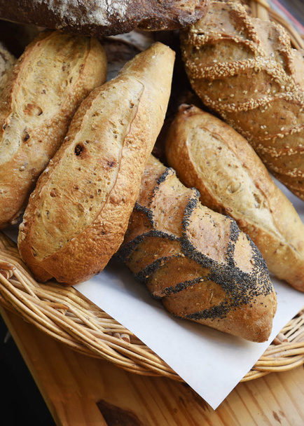 Close view of different kinds of bread in wicker basket - Photo, Image