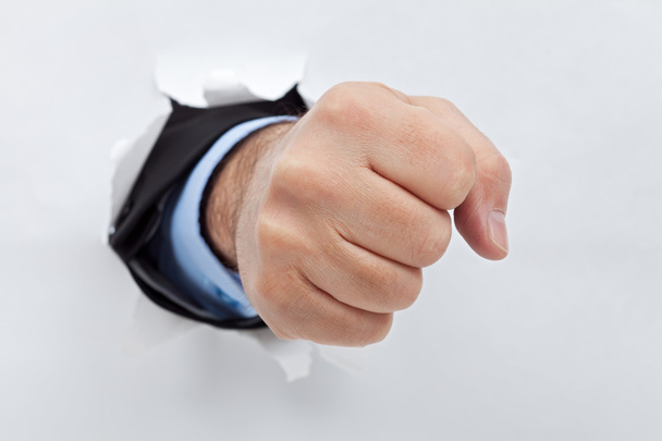 Бізнесмен кулак через папір
 - Фото, зображення