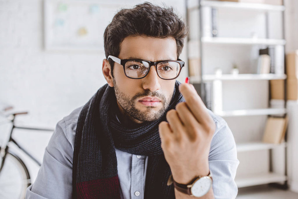 sick manager in scarf and glasses looking at pill in office - 写真・画像