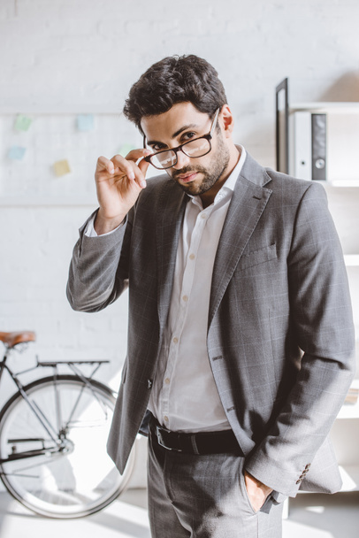 handsome businessman looking above glasses in office - Foto, immagini