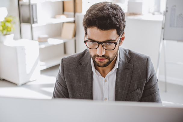 handsome businessman in glasses looking at computer in office - Photo, Image