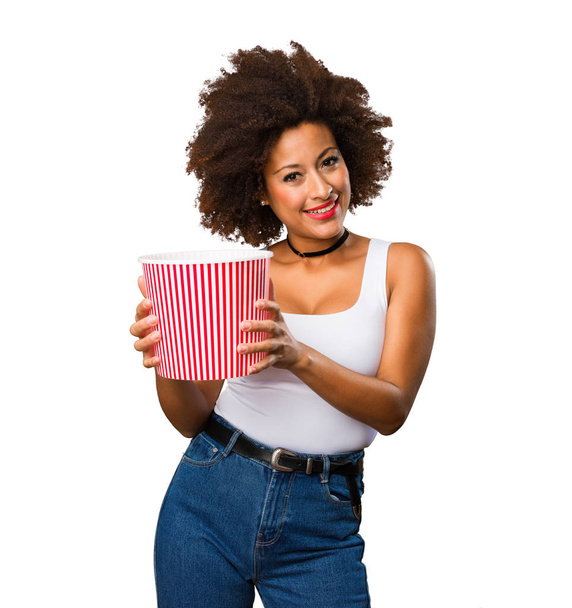 young black woman holding a popcorn bucket - Foto, imagen