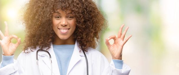 Африканская американская женщина врач, медицинский работник делает хорошо знак жеста обеими руками выражая медитацию и расслабление
 - Фото, изображение