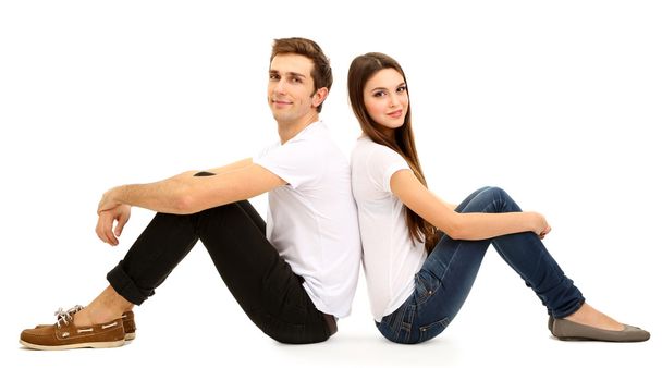 Loving couple sitting with back to each other on floor isolated on white - Фото, изображение