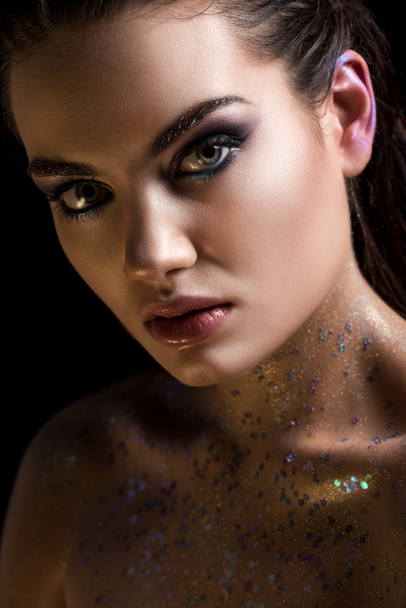 glamorous model posing with glitter on body for fashion shoot, isolated on black - 写真・画像