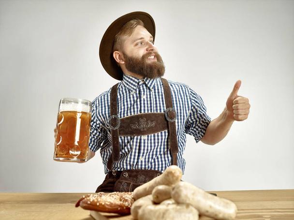 Germany, Bavaria, Upper Bavaria, man with beer dressed in traditional Austrian or Bavarian costume - Foto, Imagem