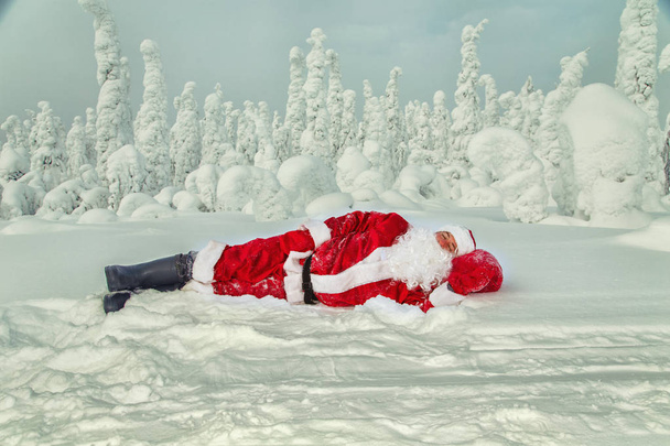 Tired Santa Claus fell asleep in the open air. Magnificent snow-covered landscape. - Foto, immagini
