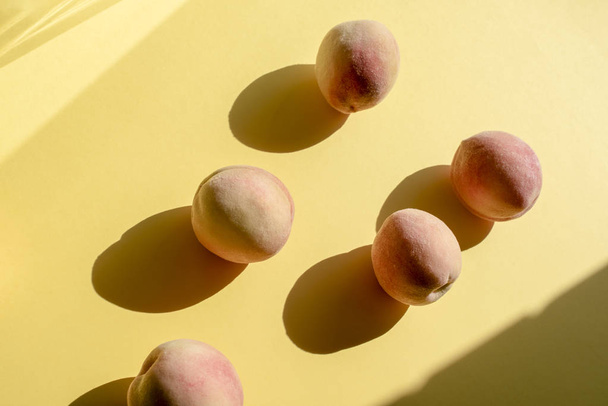 Целые спелые красивые персики на желтом фоне
 - Фото, изображение
