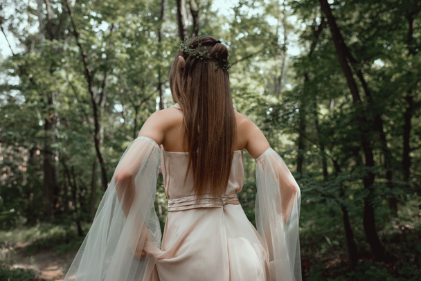 back view of mystic elf in elegant dress in forest - Foto, immagini