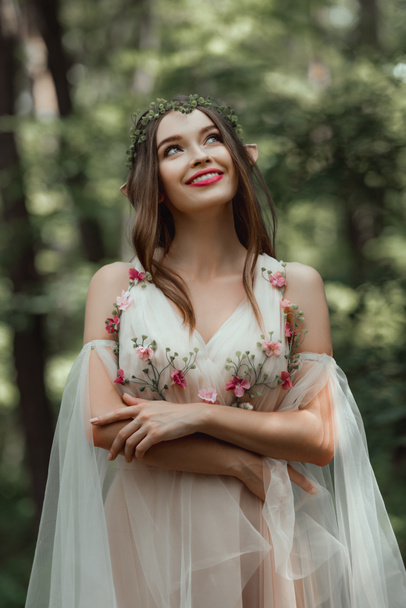 young dreamy woman with elf ears in dress with flowers - Fotoğraf, Görsel