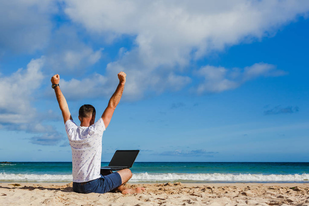 Happy exited man with raised hands up celebrate success in job or great news in front of laptop - Zdjęcie, obraz