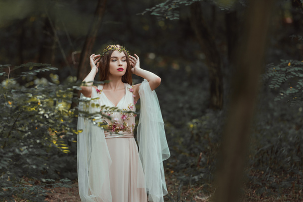 fantasy girl with elf ears in flower dress posing in forest - Photo, Image